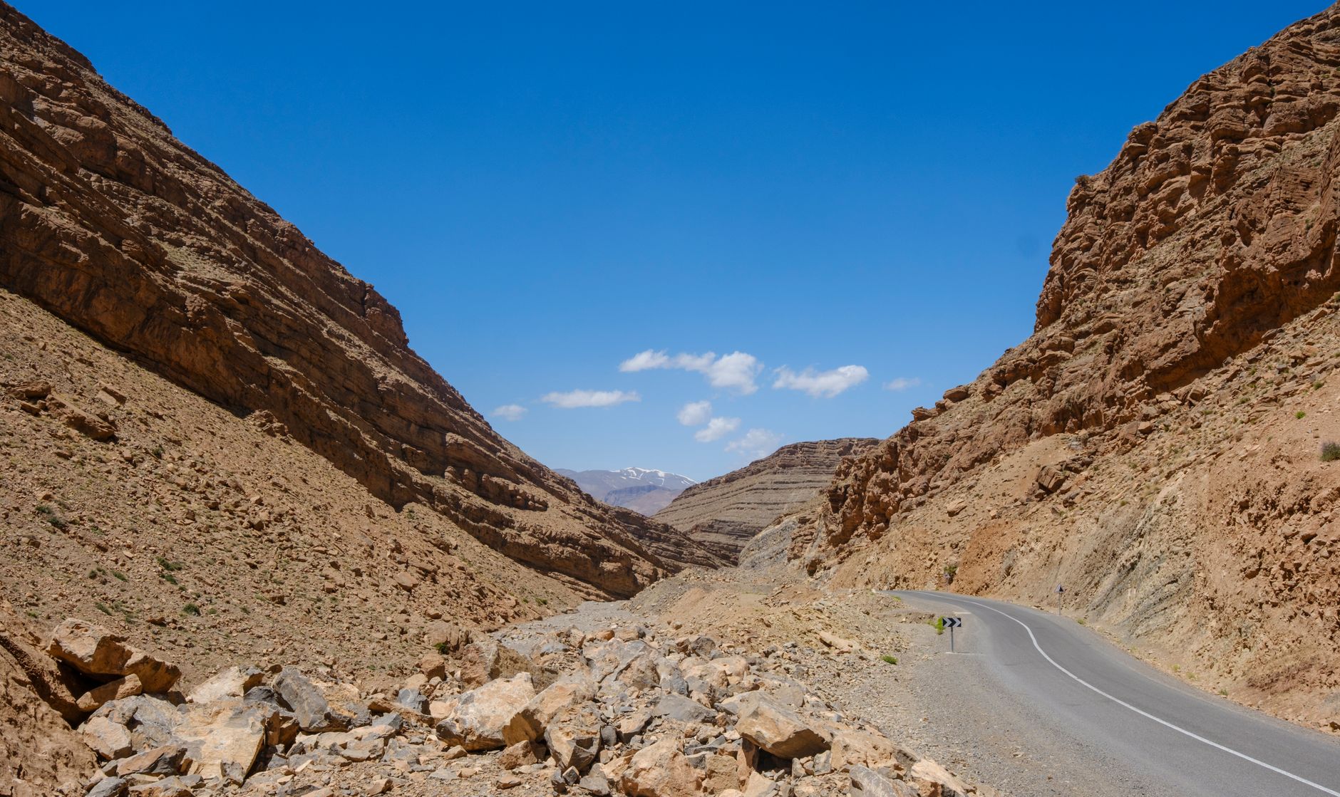 Arid mountain landscape in southern Morocco with palm oasis valley in the foreground