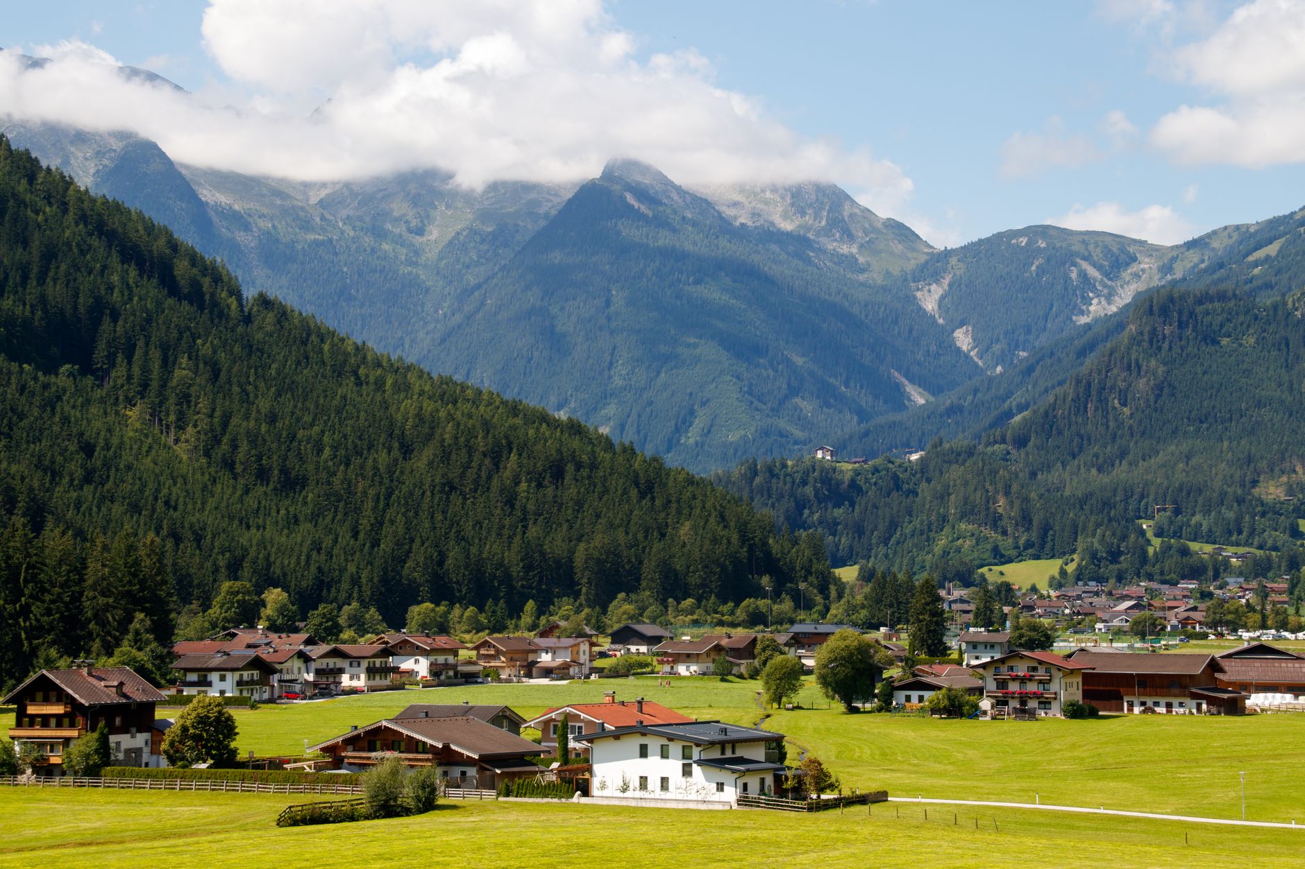 Small remote mountain village surrounded by steep rocky peaks and green terraced fields