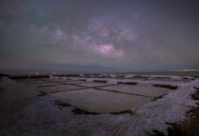 Wide view of the Uyuni Salt Flats reflecting a star-filled night sky in Bolivia