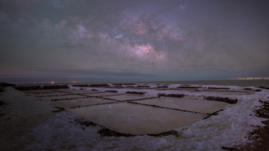 Wide view of the Uyuni Salt Flats reflecting a star-filled night sky in Bolivia