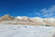 Mountain road through a Central Asian pass leading into a fertile valley