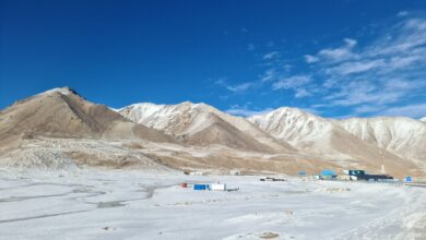 Mountain road through a Central Asian pass leading into a fertile valley