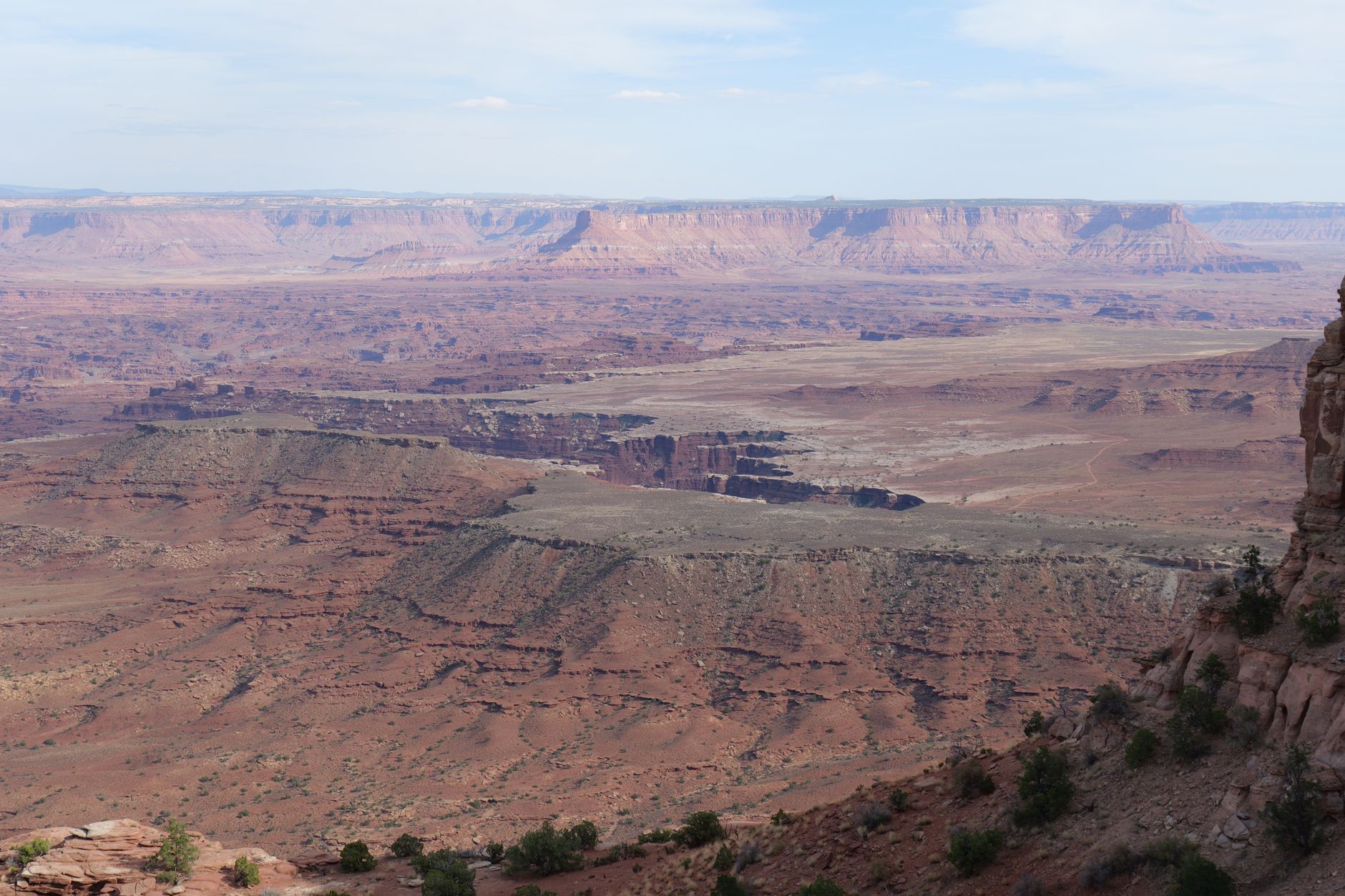 Ochre and rust-red canyon walls of the high-altitude Mustang plateau under a clear blue sky