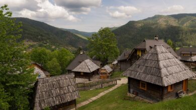 Traditional wooden village houses on a green mountain plateau in Serbia