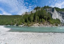 Crystal-clear turquoise river flowing through a forested alpine valley in Slovenia