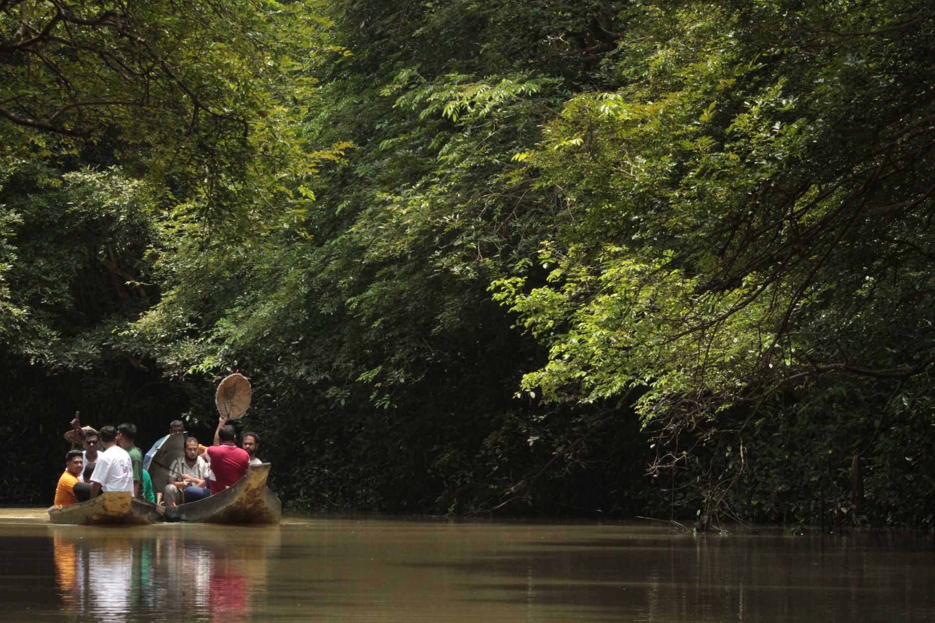 Travelers paddling a canoe on a calm African river surrounded by wildlife