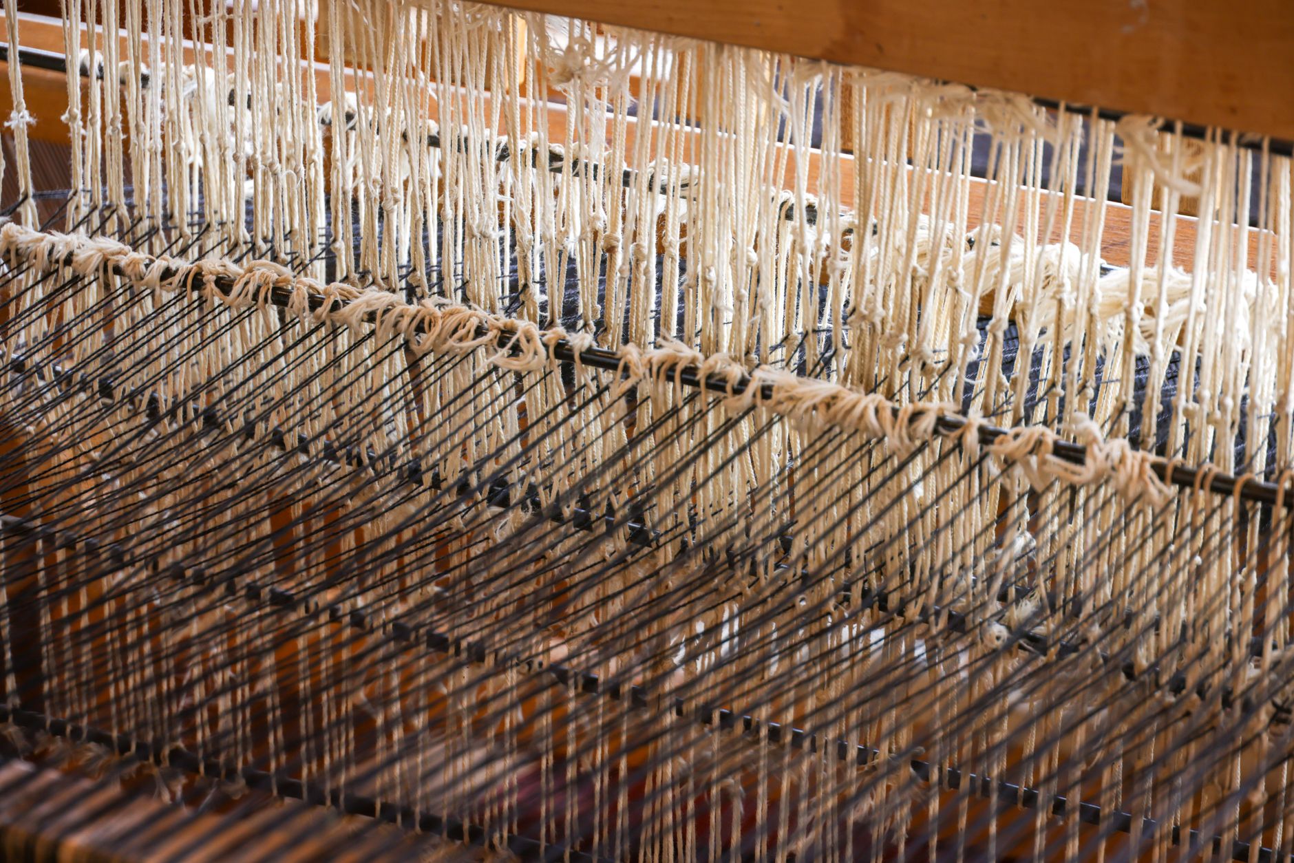 A weaver working at a traditional hand loom producing ikat-pattern silk fabric