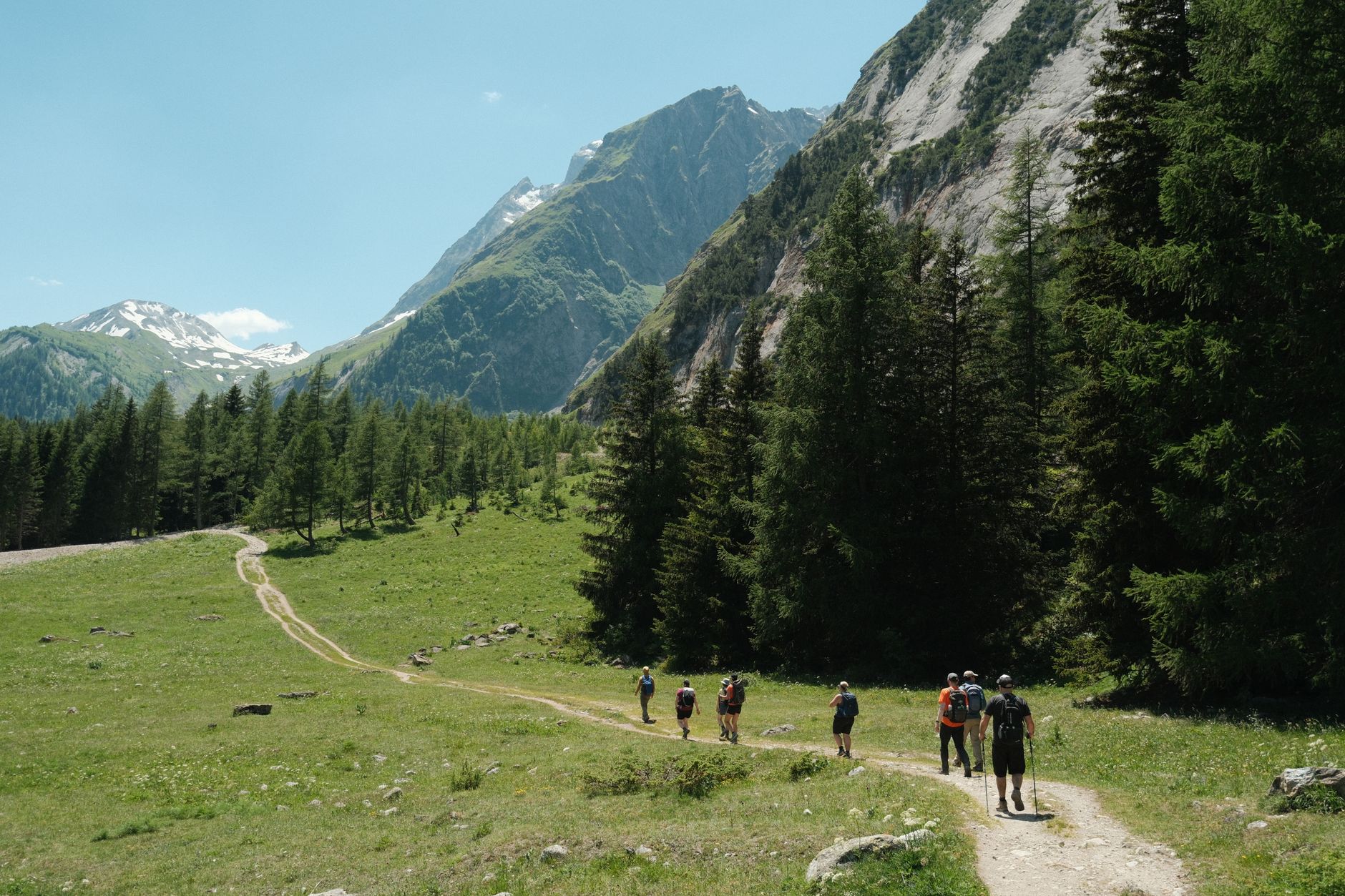 Trekker walking along a remote mountain ridgeline at high altitude