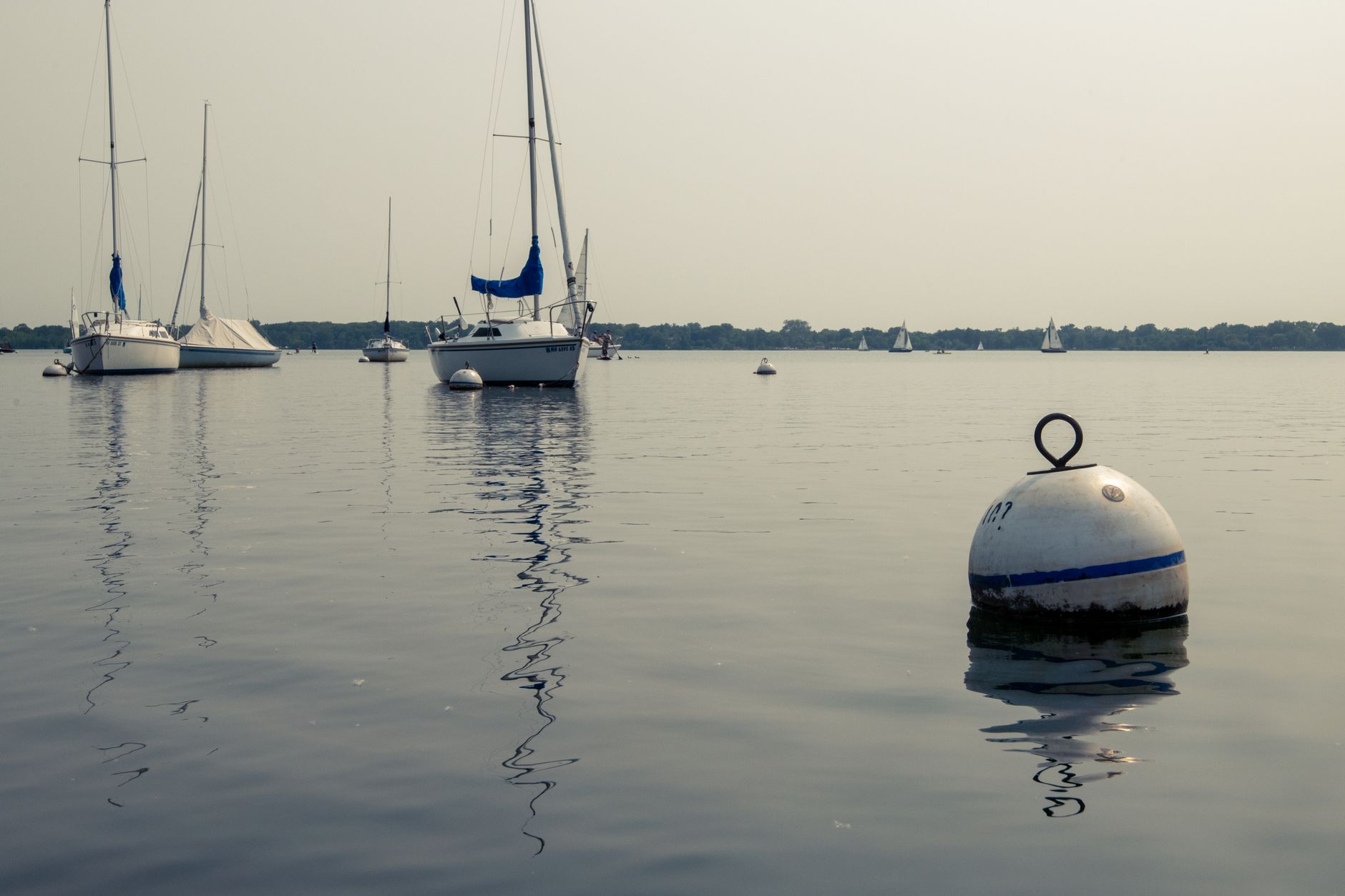 Sailboat anchored in clear shallow water near a tropical island