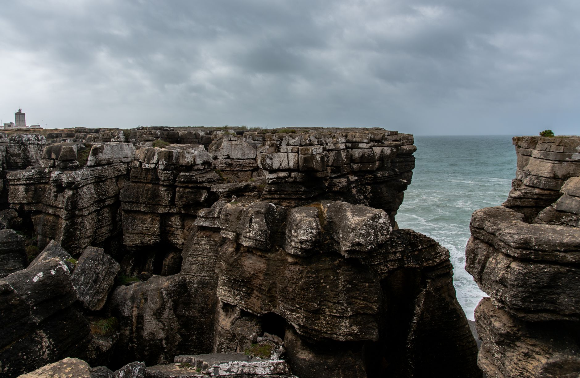 Steep green cliffs dropping to a gray Atlantic Ocean under overcast skies