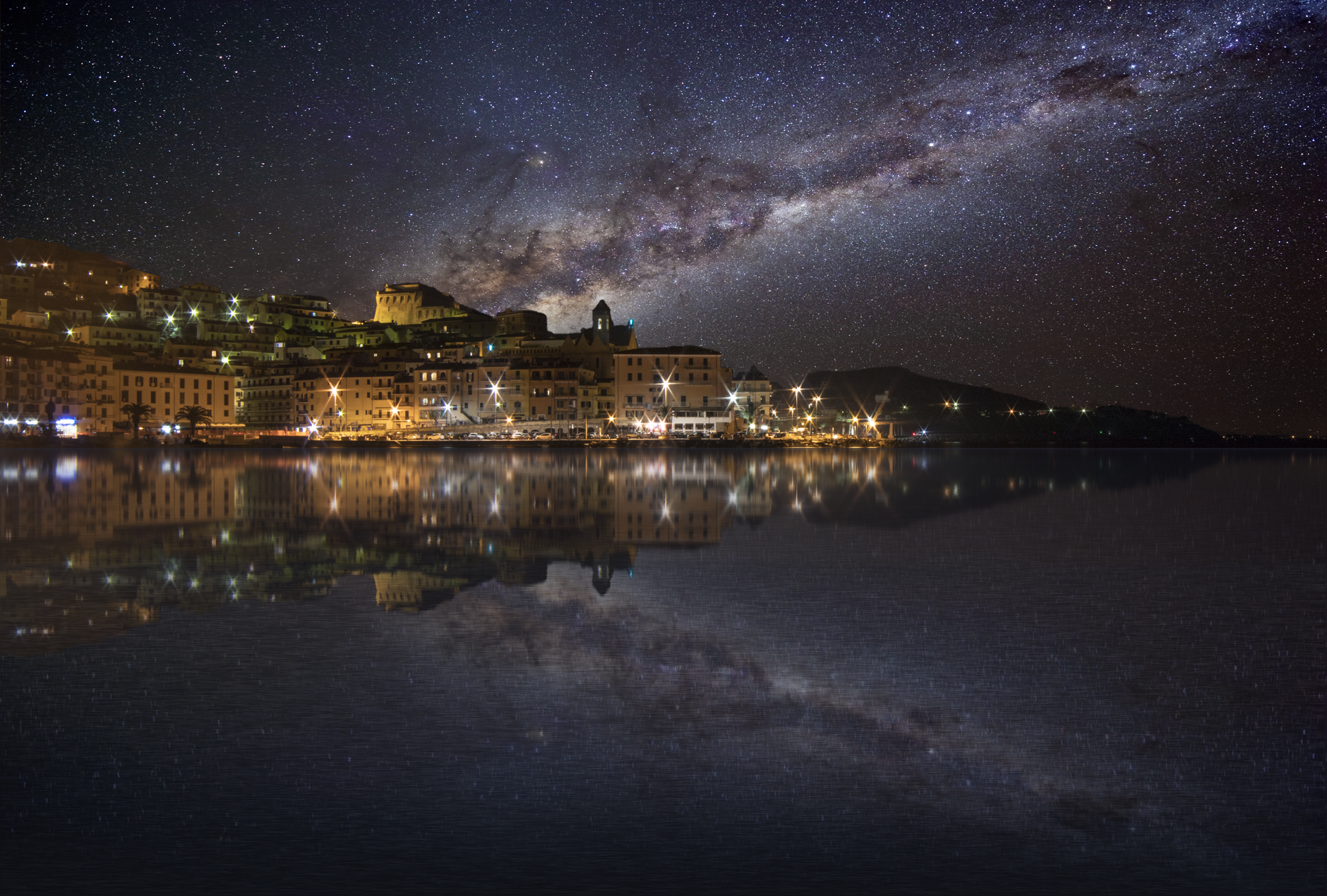 Milky Way galaxy reflected on a thin water layer across a flat landscape at night