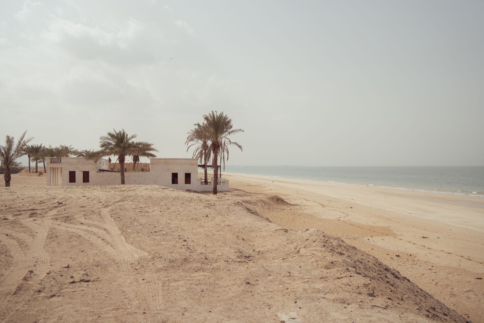 An empty white-sand beach with turquoise water along the Dhofar coast of Oman