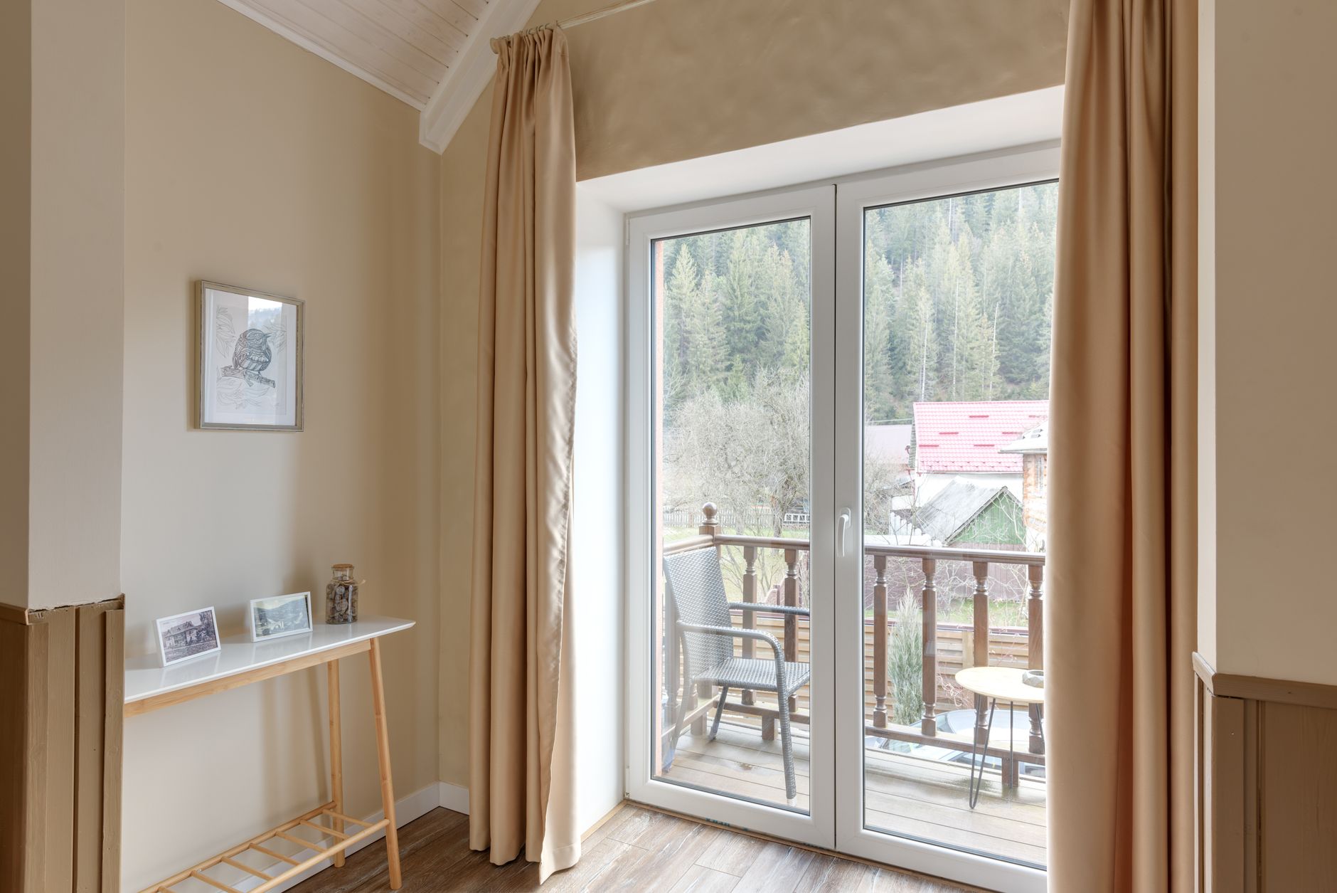 Wooden lodge veranda overlooking a green forest landscape at dawn