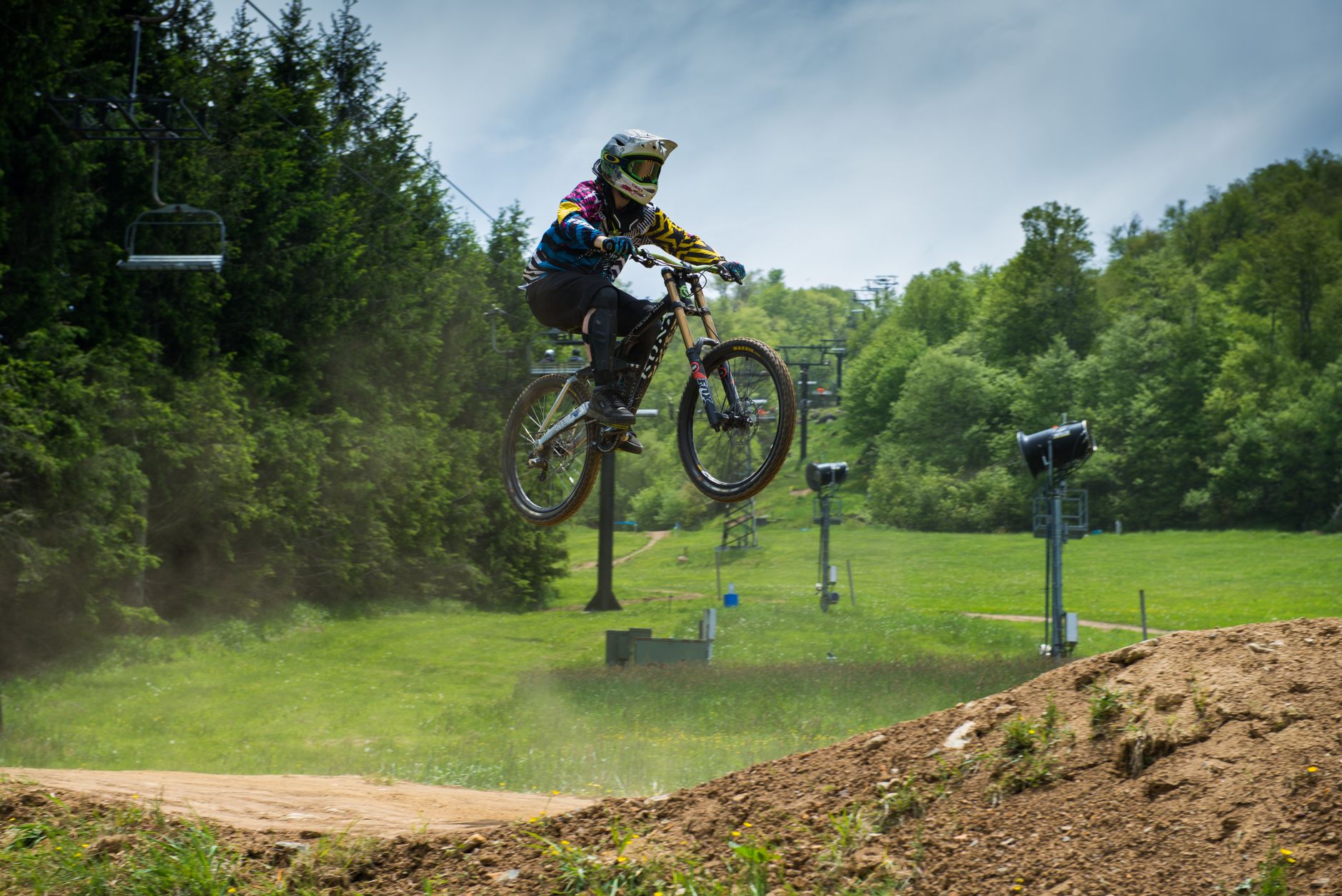 Cyclist descending a steep rocky mountain trail on a full-suspension mountain bike