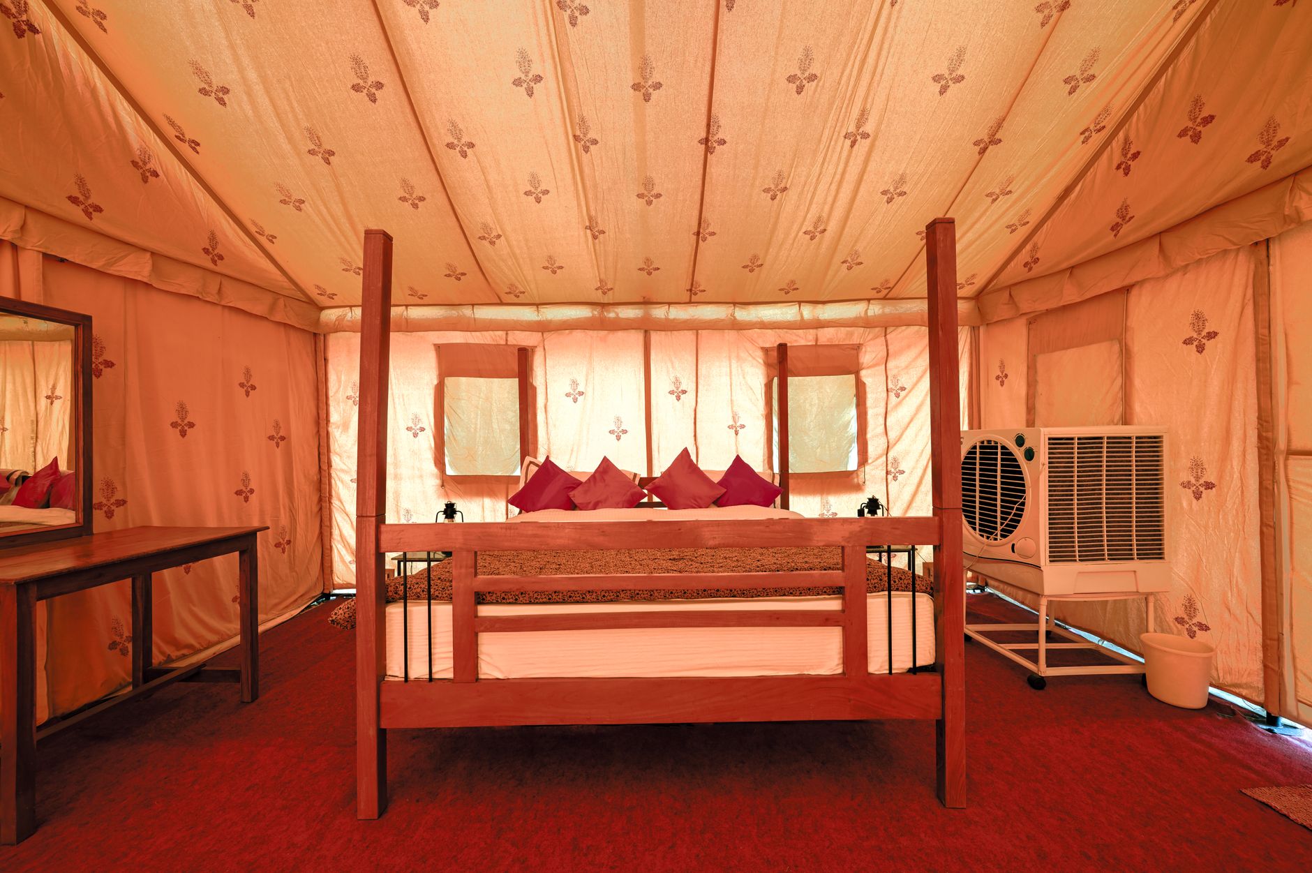 Small luxury safari tented camp set against an African bush landscape at dusk