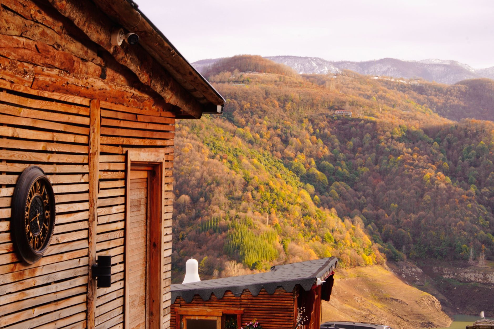 Rustic guesthouse terrace in a mountain valley with views of forested slopes
