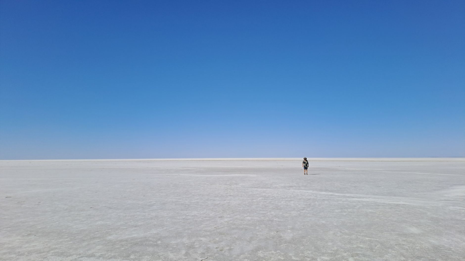 Vast salt flat terrain under harsh sunlight in a remote desert region