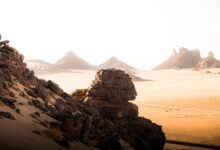Dramatic volcanic rock spires rising from the Algerian Sahara desert at dusk