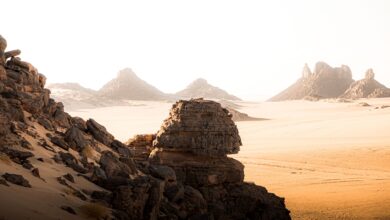 Dramatic volcanic rock spires rising from the Algerian Sahara desert at dusk