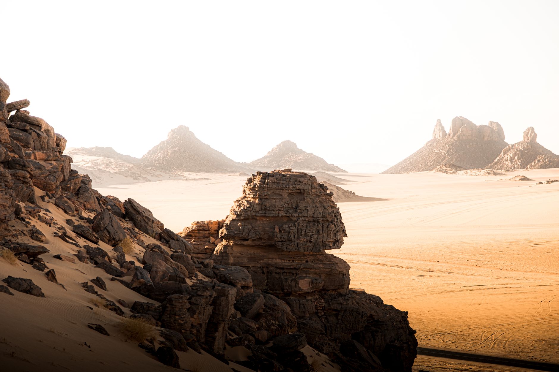 Dramatic volcanic rock spires rising from the Algerian Sahara desert at dusk