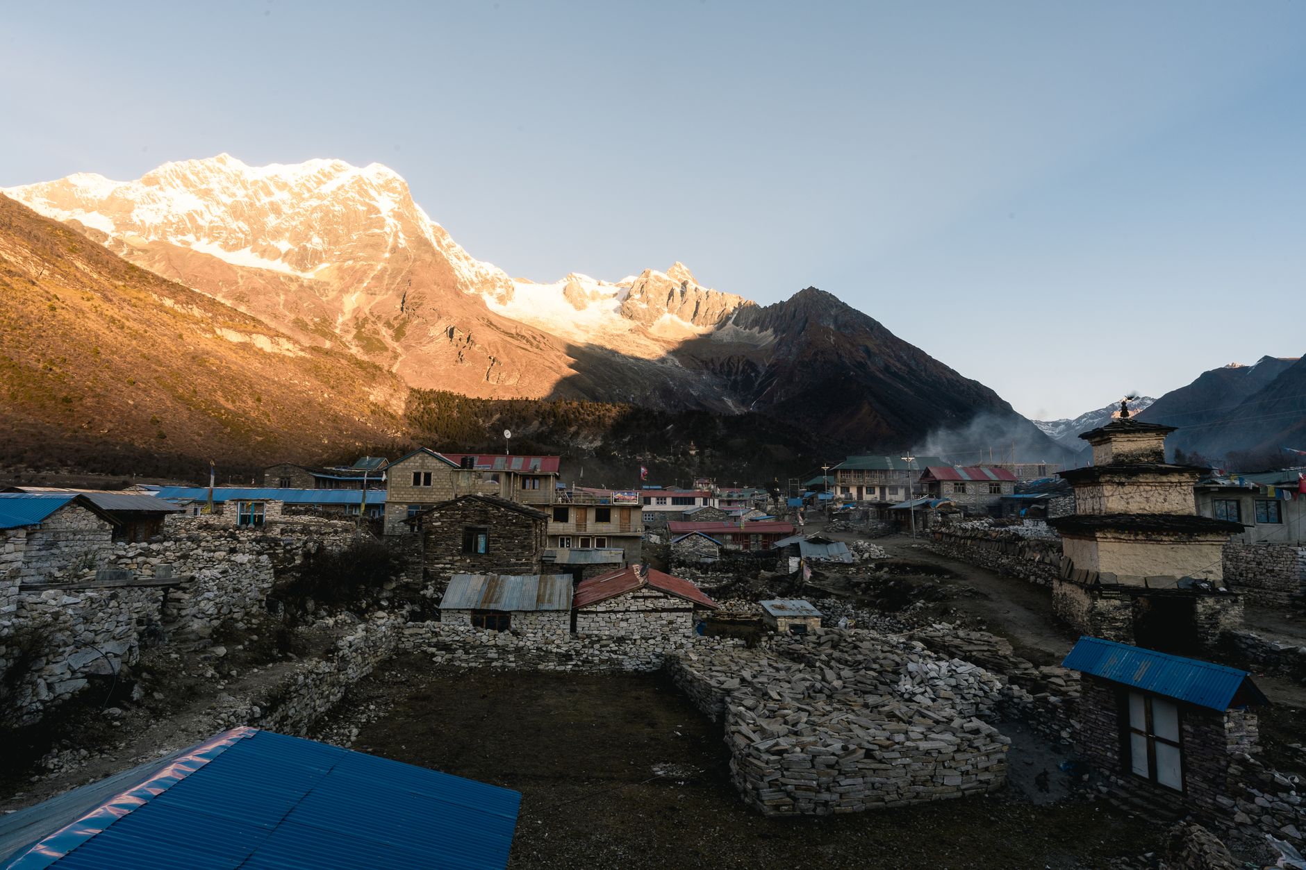 Traditional mud-brick village buildings in Nepal's high-altitude Mustang district under a clear blue sky