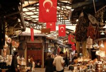 Colorful open-air market stalls along a river in a Central Asian city