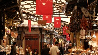Colorful open-air market stalls along a river in a Central Asian city
