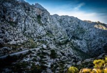Steep unpaved mountain pass road winding through high altitude terrain in southern Africa