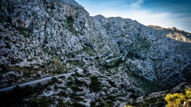 Steep unpaved mountain pass road winding through high altitude terrain in southern Africa