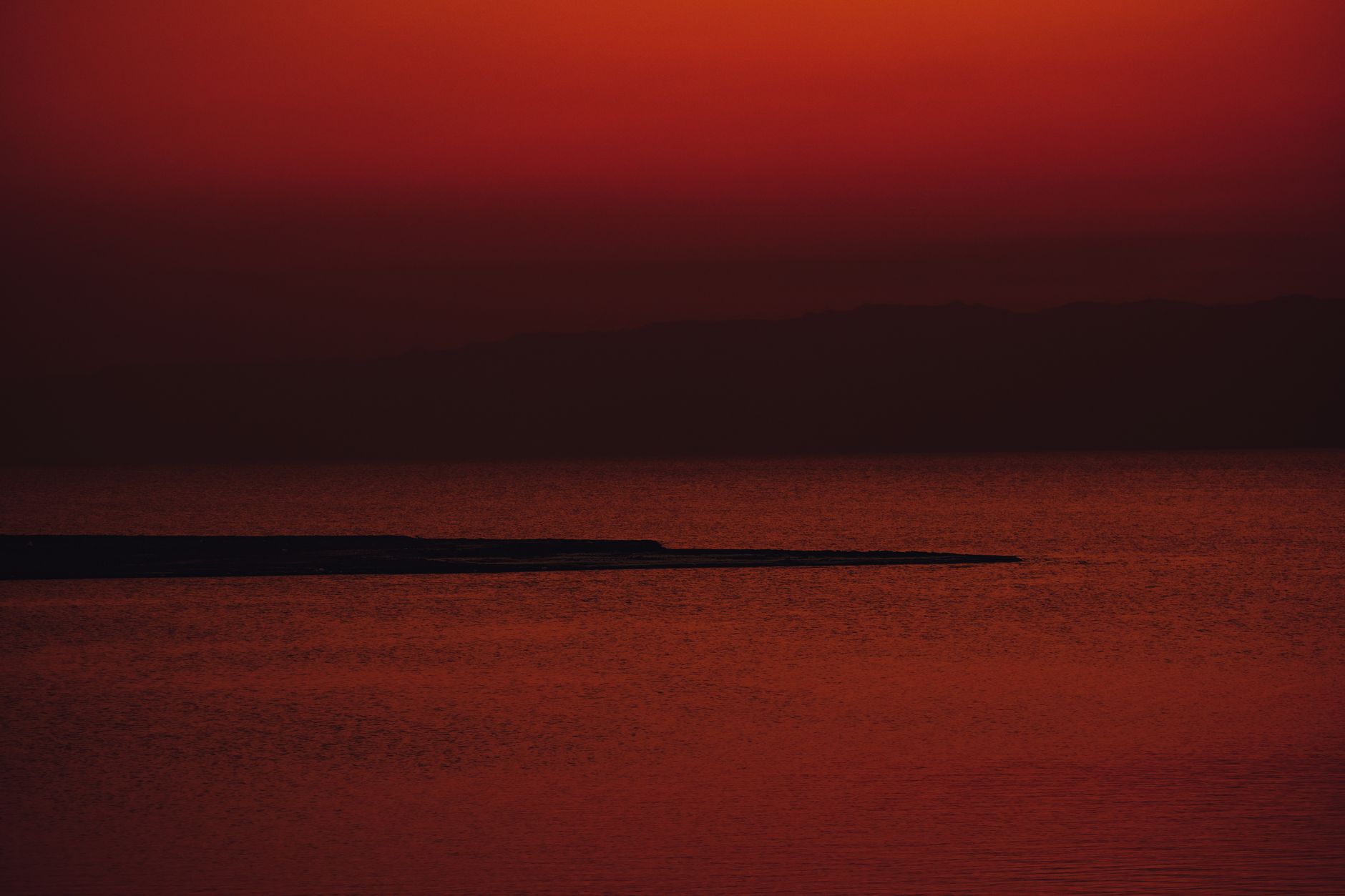 Calm Red Sea coastline with turquoise water and rocky limestone shore