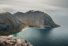 Dramatic rocky coastline meeting a calm sea under a wide blue sky