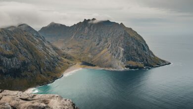 Dramatic rocky coastline meeting a calm sea under a wide blue sky