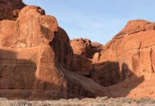 Towering red sandstone rock formations rising from the flat desert floor of Wadi Rum, Jordan