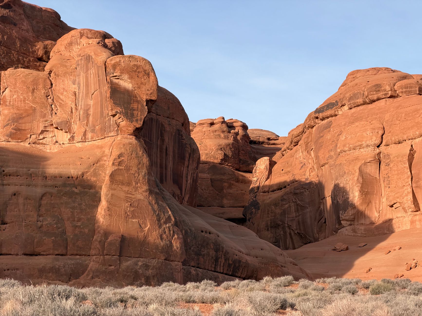 Towering red sandstone rock formations rising from the flat desert floor of Wadi Rum, Jordan