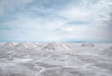 Vast white salt flats of the Salar de Uyuni stretching to the horizon under a blue sky