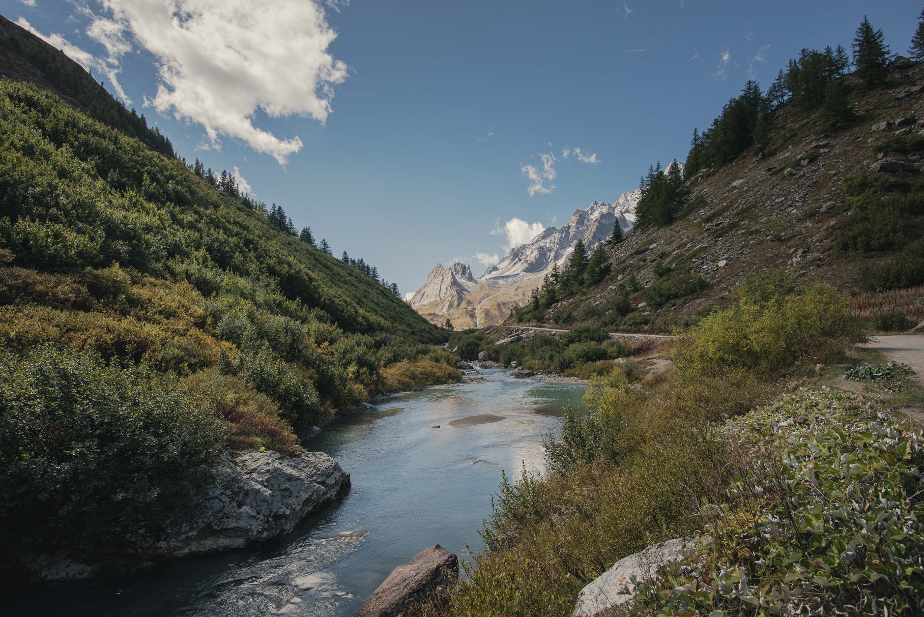 A narrow mountain valley with a river running through remote Central Asian terrain
