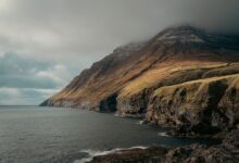 Dramatic coastal cliffs of the Faroe Islands with Atlantic Ocean below under overcast skies