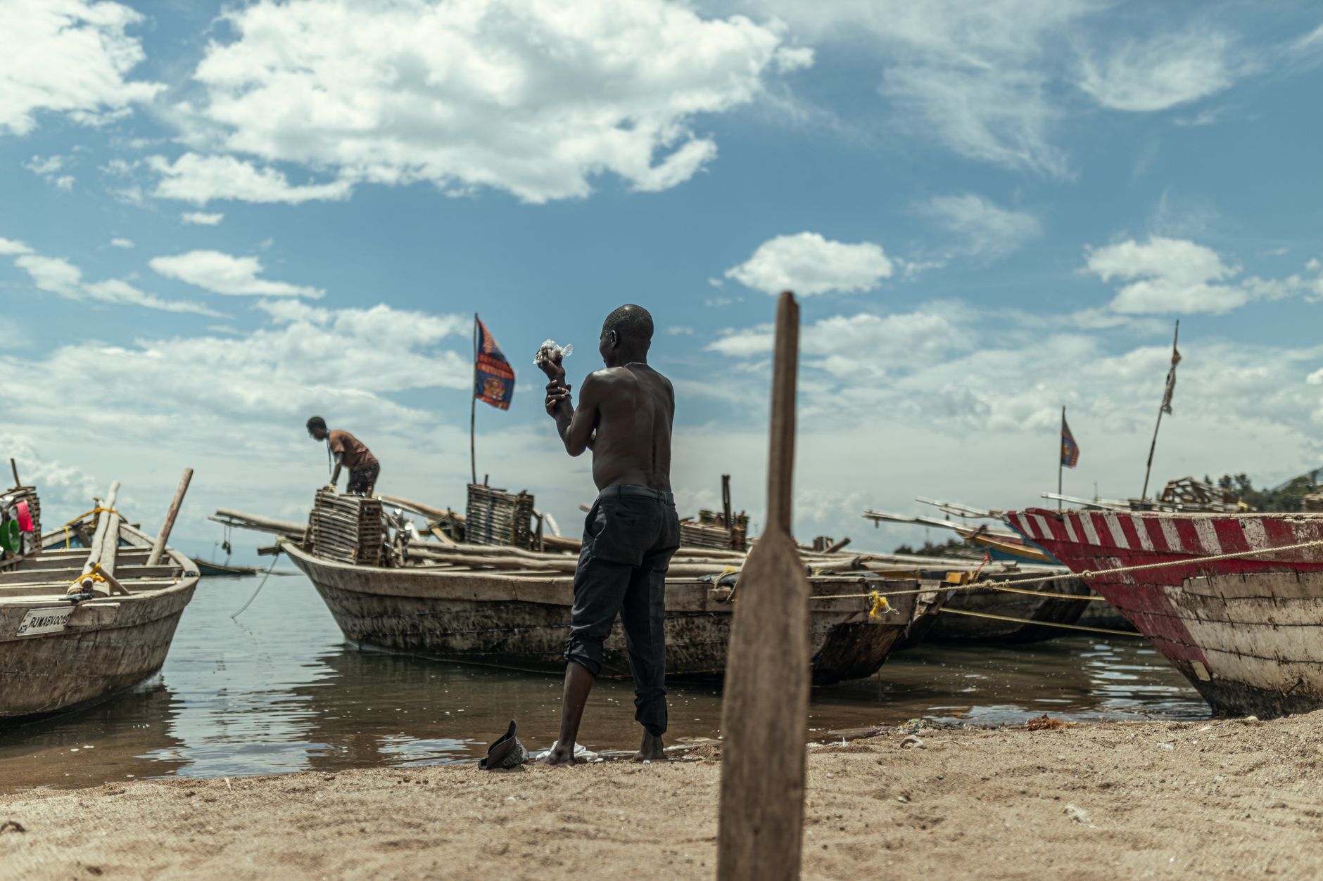 Calm lake shoreline in Africa with baobab trees and clear blue water