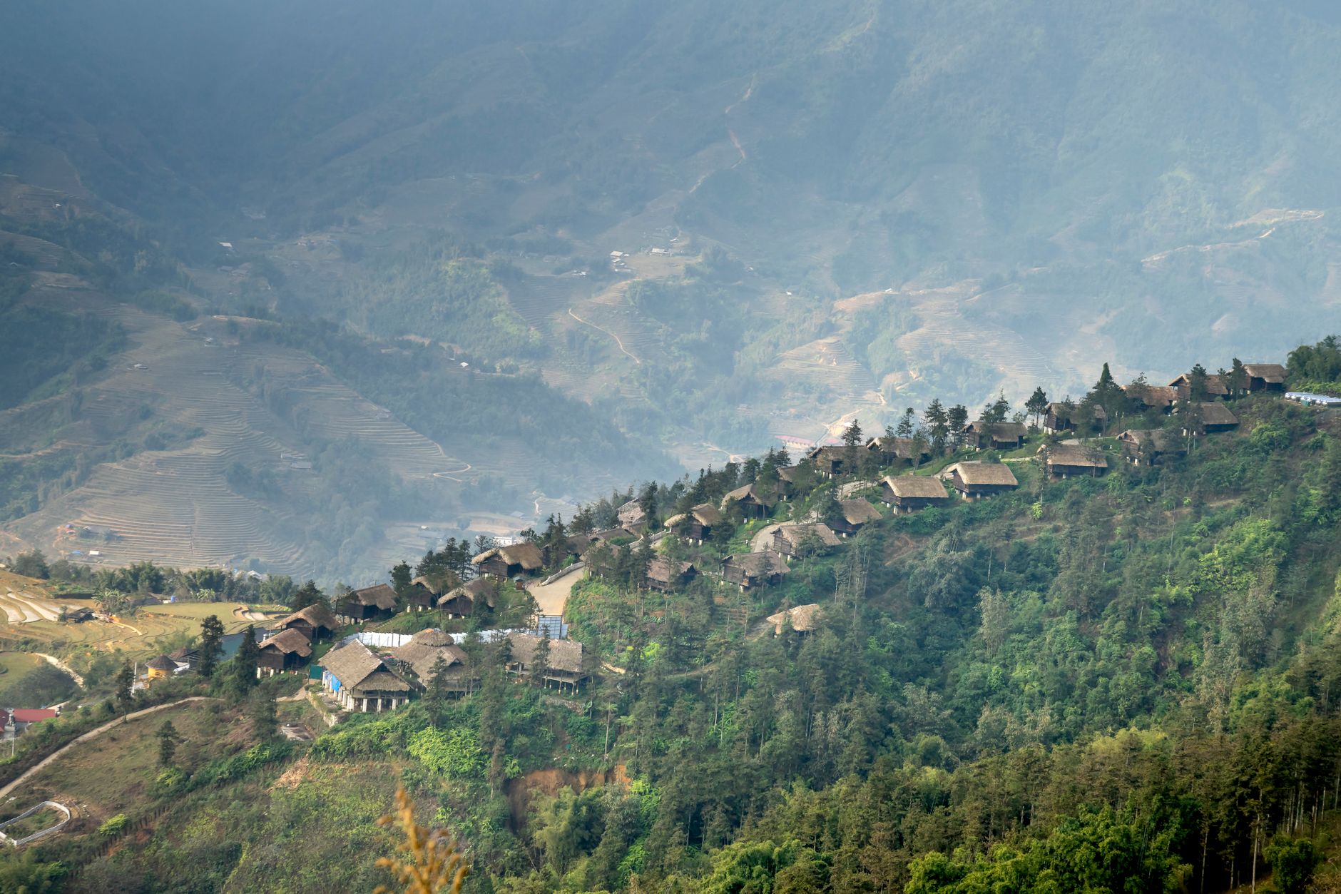 Traditional stone guesthouse in a remote mountain village surrounded by green hills