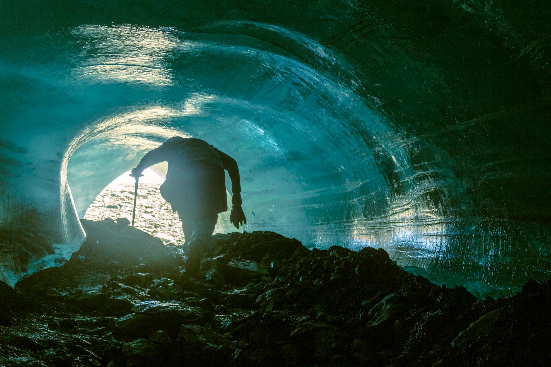 Blue-tinted underground ice formation lit by artificial lighting inside a cave