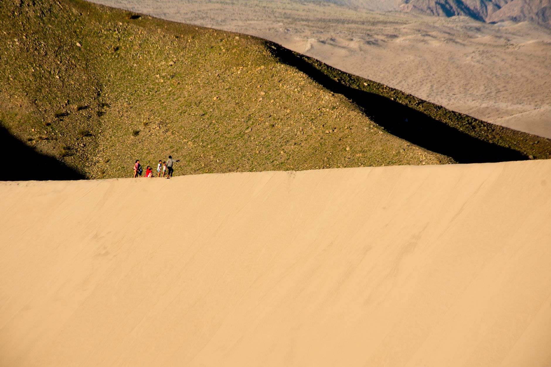 Trekker on a rocky desert plateau with vast open landscape stretching to the horizon