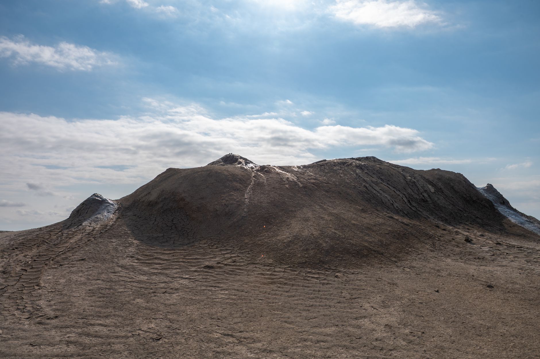 Gray bubbling mud volcano formation in a dry desert landscape