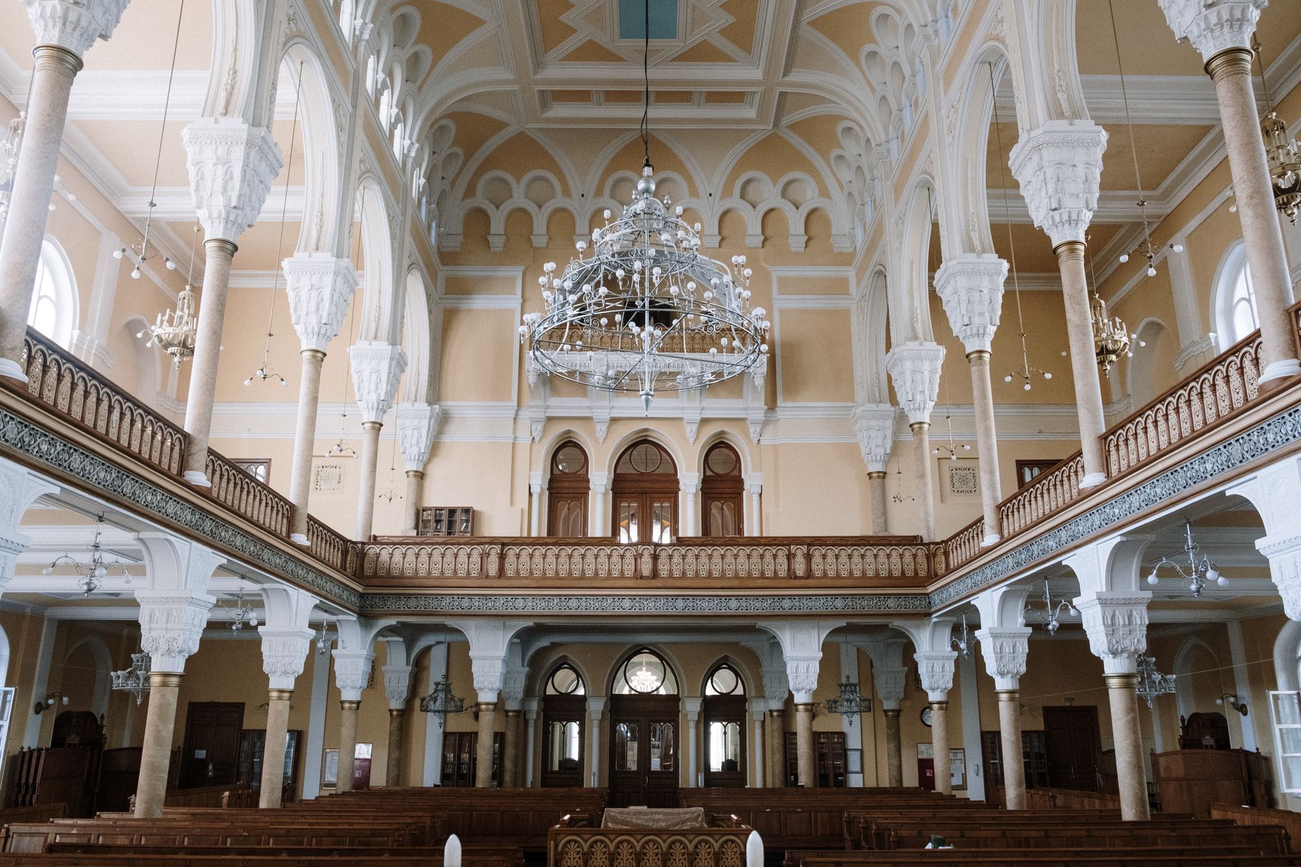 Interior of an ancient synagogue with ornate tiled walls and candles