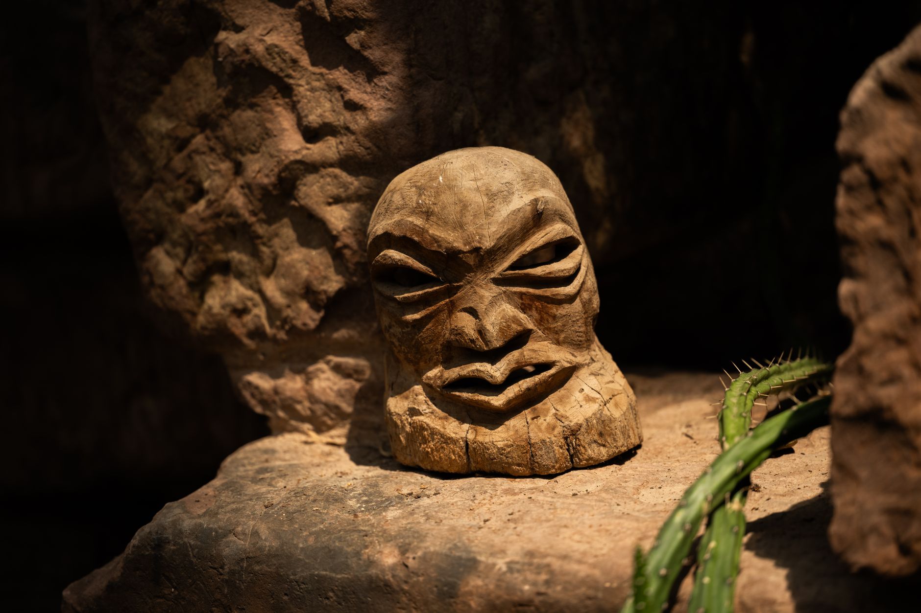 An intricately carved wooden ceremonial mask with geometric patterns and natural pigments