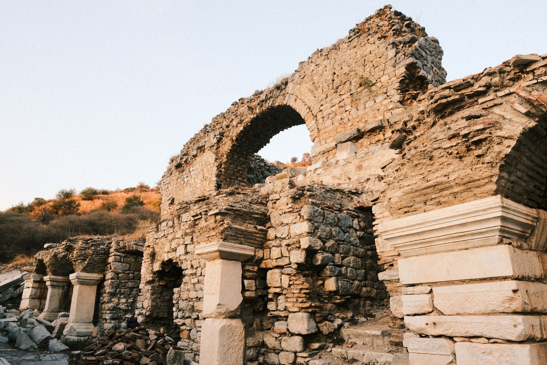 Crumbling stone fortress ruins on a rocky hillside overlooking a high-altitude valley