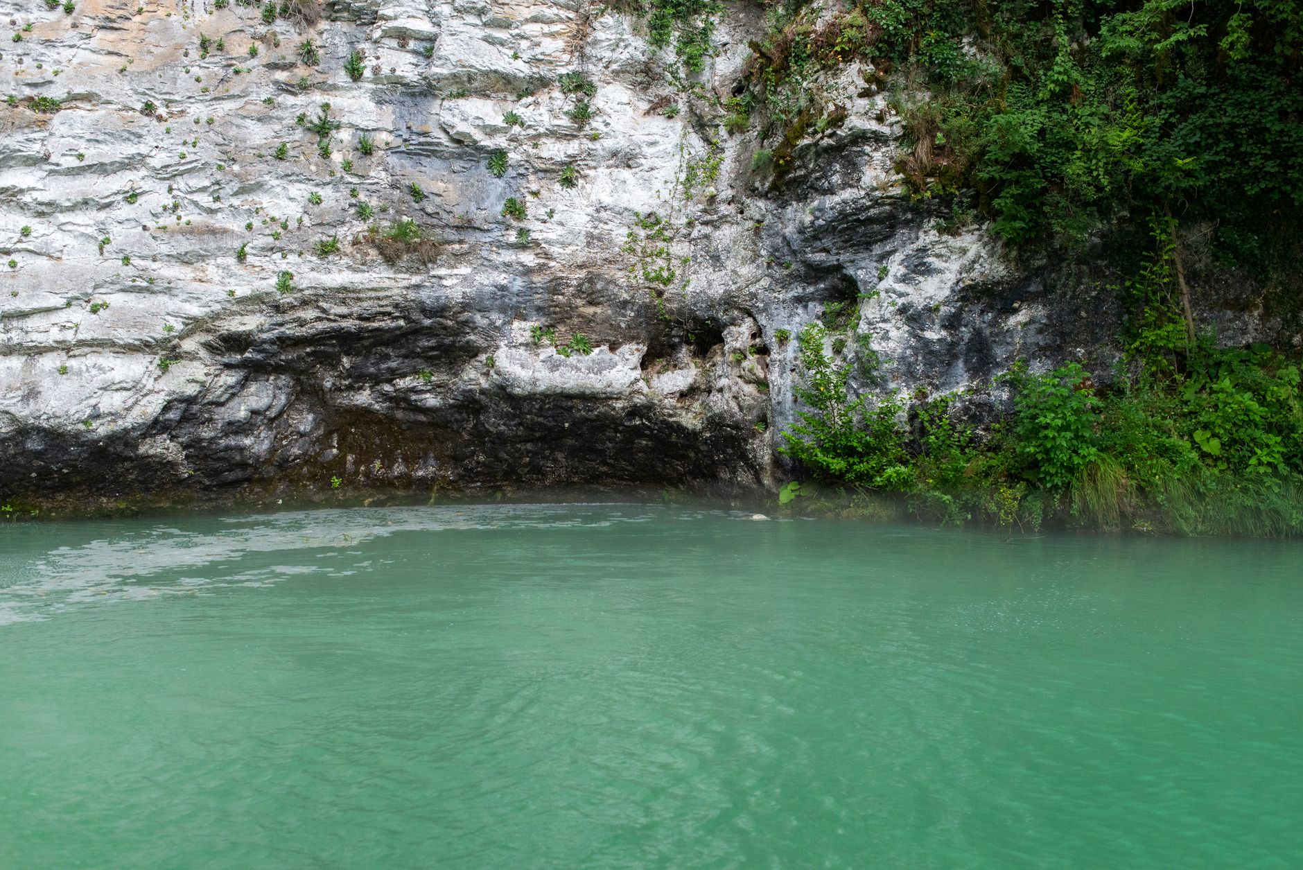 A lake perched near a cliff edge appearing to float above the ocean in an optical illusion landscape