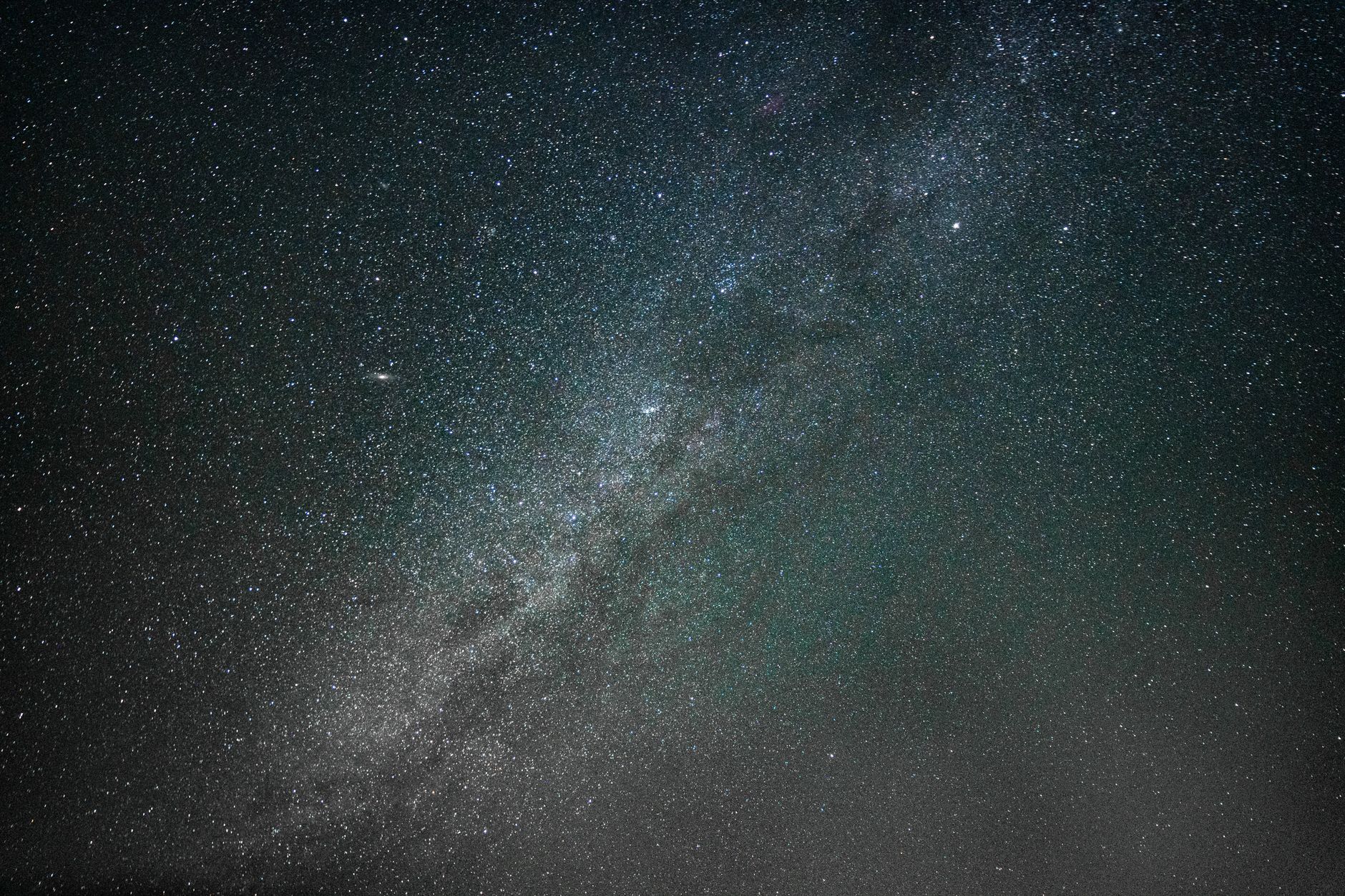Vivid Milky Way galaxy arc visible over a dark desert horizon