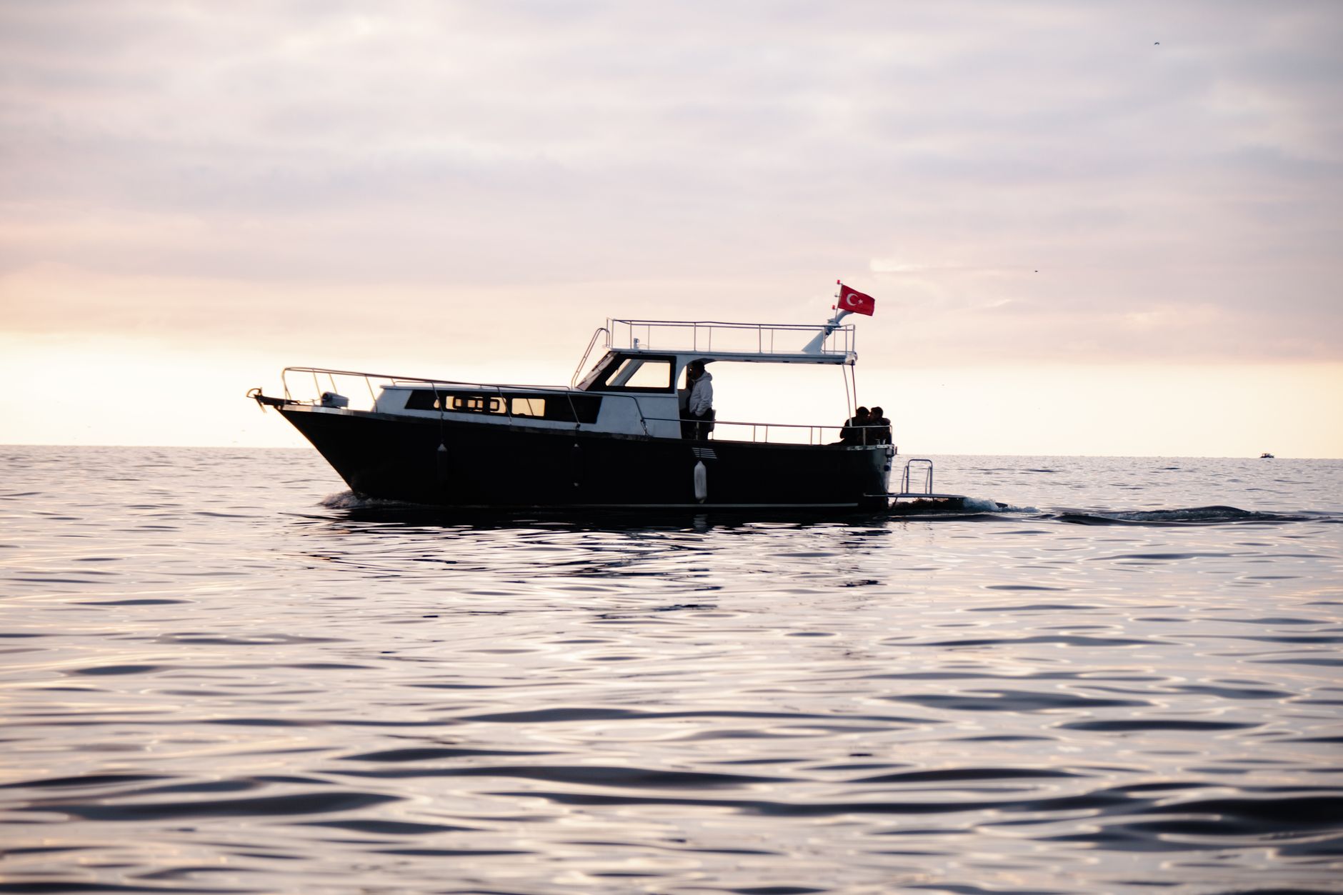 Small liveaboard vessel anchored near a remote tropical island