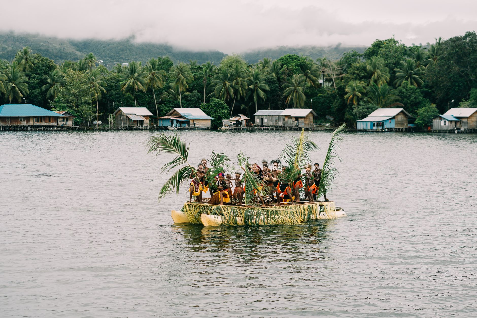 Traditional village on a jungle ridge overlooking calm tropical water