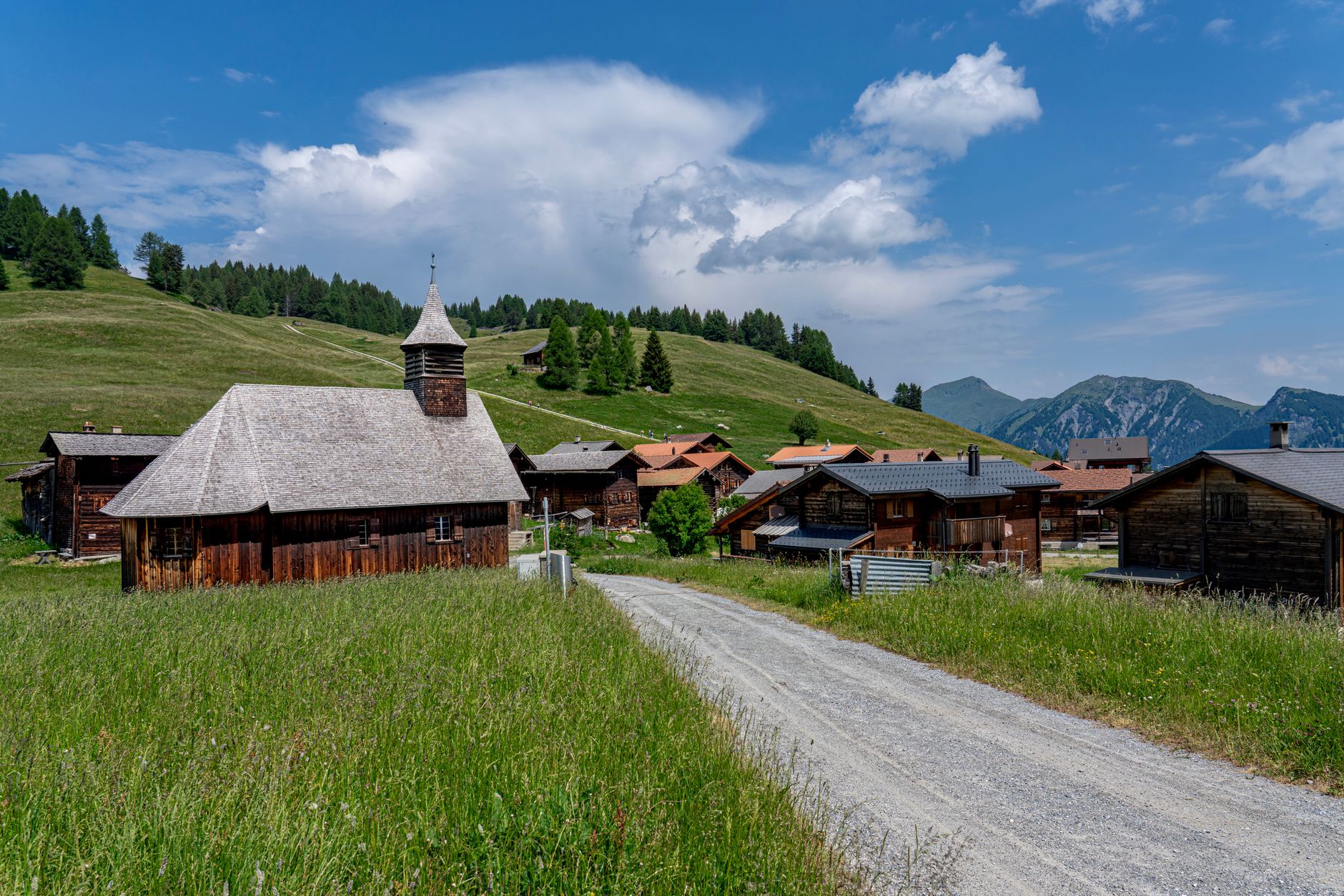 A narrow footpath connecting hillside villages in a forested mountain region